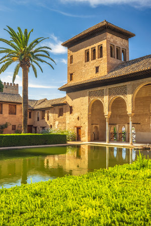 The Partal Palace in the Alhambra complex, Granada, Andalusia, Spain. Serene courtyard with reflecting pool, traditional architecture, and lush greenery.の写真素材