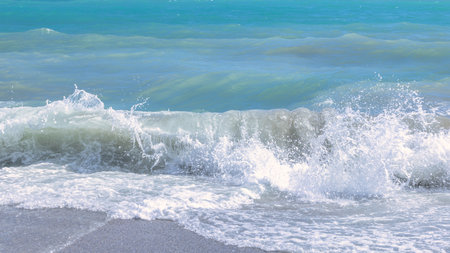 Nerja town, a resort of The Costa del Sol seaside region in Andalusia in the south of Spain. Ocean wave crashing on sandy beach, creating white foam and splashes.の写真素材