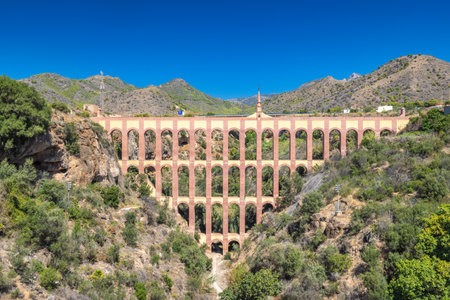 Aguila aqueduct, bridge near The Nerja seaside town of The Costa del Sol coastline in Andalusia. Ancient aqueduct spanning a valley, impressive architecture against a backdrop of mountains.の写真素材