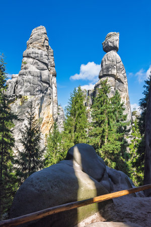 Adrspach-Teplice Rocks, sandstone formations in Hradec Kralove Region in Czech Republic, Europe. Spectacular rock formations tower above lush green trees, a natural landscape under a bright blue sky.の写真素材