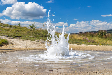 Dynamic water jet shooting upwards, creating a captivating display of motion and energy. This...