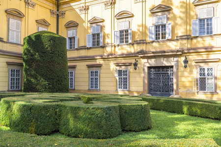 Buchlovice, Czech Republic - October 11, 2024: The Buchlovice castle. An ornate garden design complements a large yellow building, showcasing artistry in both landscape and architecture.のeditorial素材