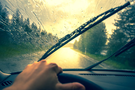 Driving on a rainy day through the windshield of a car.