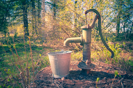 Old rusty water pump in the forest. Retro style toned pictureの写真素材