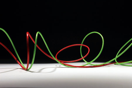 Red and green wires That twists on a black and white background.の写真素材