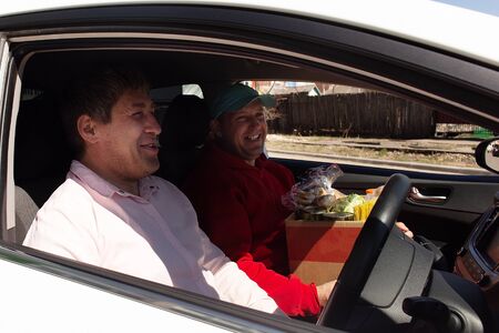 the men in the car with food, volunteersの写真素材