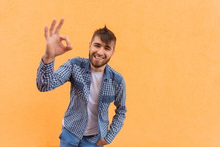 the beautiful and happy man shows with his hand that everything is fineの写真素材