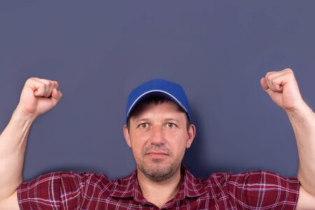 the strong man in a cap on a blue backgroundの写真素材