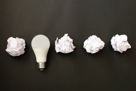the electric lamp and crumpled paper on a black background