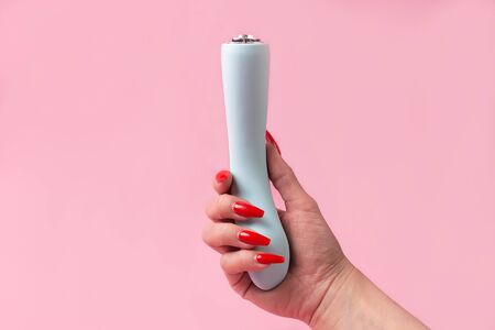 the Dildo in hand on a pink background, sex toyの写真素材