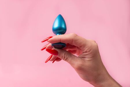 the Dildo in hand on a pink background, sex toyの写真素材