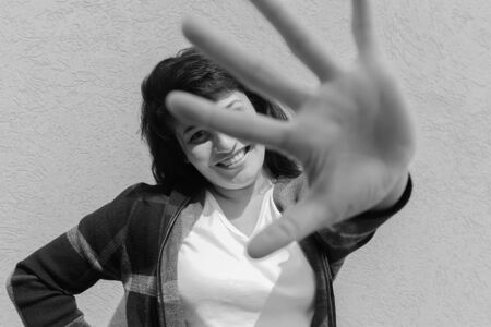 the Girl closes her hand from the camera, black white photoの写真素材