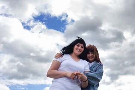the Happy mother and daughter against the sky