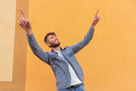 the beautiful and happy man against the orange wallの写真素材