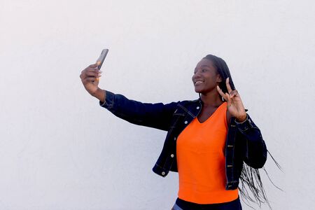 the Beautiful and happy African American takes a selfie on a white background