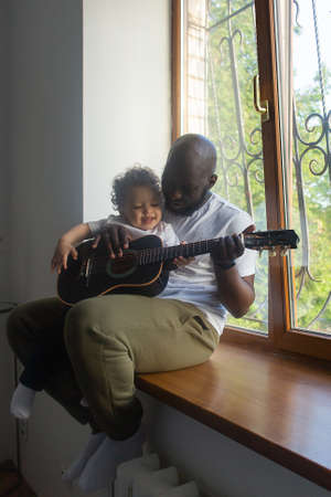 the Dad plays guitar to son song, Afro Amercansの写真素材