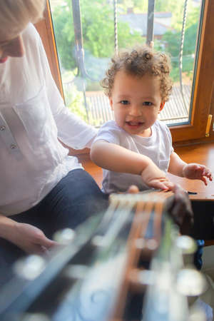 the Toddler plays guitar with mom