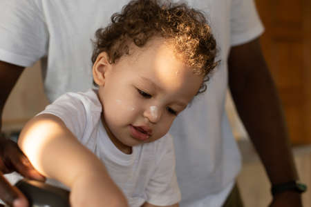 the Toddler in flour in the kitchen, close-upの写真素材