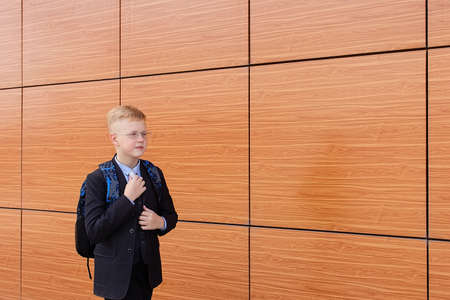 the serious schoolboy in a suit on the street