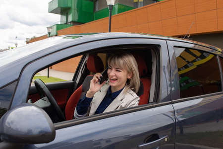 the Happy blonde talking on the phone in the car