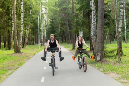 the man and woman ride bikes through the woods