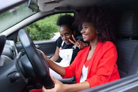 the two African American women having fun in the car