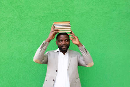 the African American student with a book on a green background