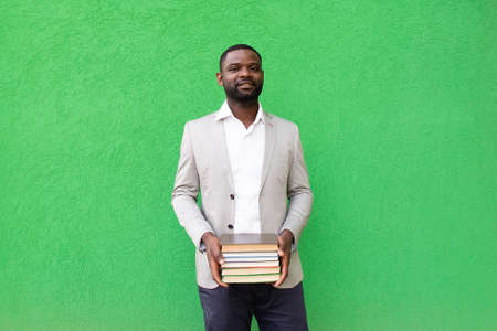 the African American student with a book on a green backgroundの写真素材