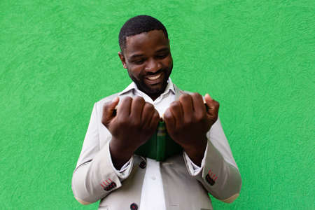 the African American student with a book on a green backgroundの写真素材