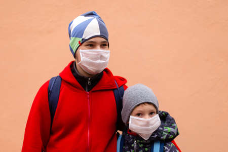 the schoolchildren in protective masks in the street