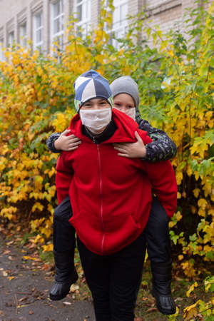 the schoolchildren in protective masks in the street