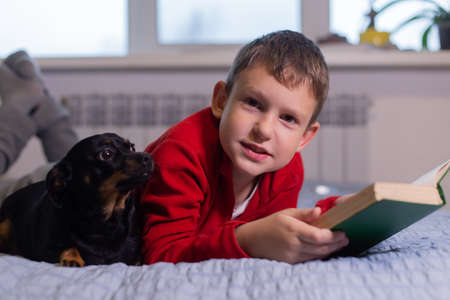 the Boy with dog reads a bookの写真素材