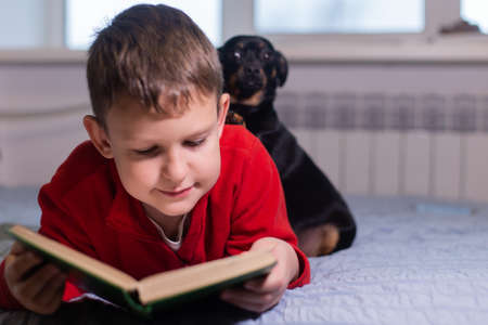 the Boy with dog reads a book