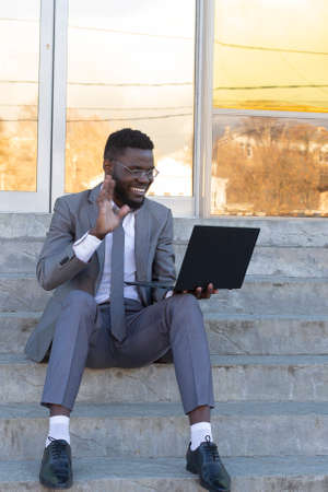the Happy African American on the street with laptop, freelancingの写真素材