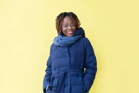 the Happy African American walks down the street in winter