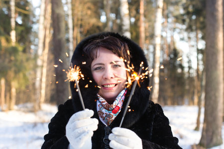 the happy woman in body in nature in winter with sparklers, Christmas