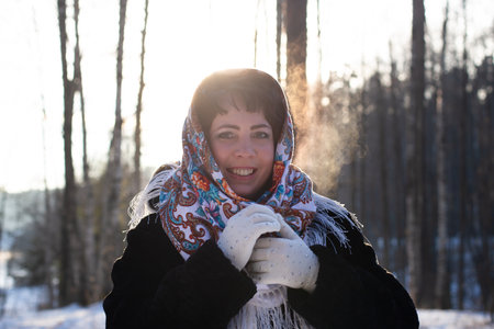 the happy woman in a body in nature in winter in a beautiful headscarfの写真素材