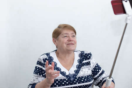 elderly woman writes a video for a blogの写真素材