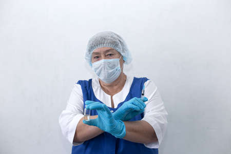 An elderly nurse holds a syringe and ampoule, vaccinationの写真素材