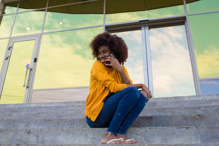Happy African American woman on the street talking on the phone