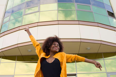 Happy and young African American woman on the street having funの写真素材