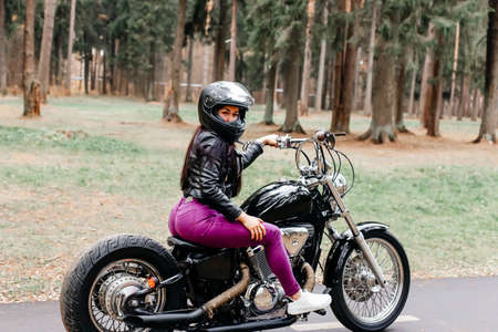 the beautiful brunette riding a motorcycle in the park