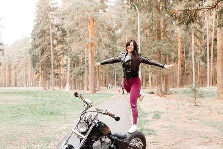 the beautiful brunette riding a motorcycle in the parkの写真素材