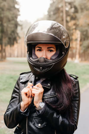 the beautiful brunette riding a motorcycle in the parkの写真素材