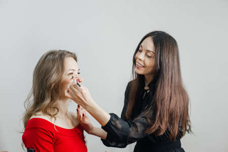the master does a beautiful blonde makeup in a beauty salonの写真素材