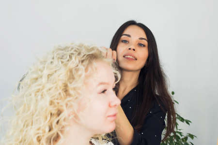 the master makes a hairstyle for a girl, beautiful curlsの写真素材