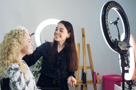 the master does a beautiful blonde makeup in a beauty salonの写真素材