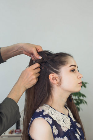 the master makes a hairstyle for a girl, beautiful curls