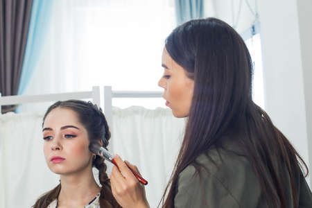 the master does a beautiful blonde makeup in a beauty salonの写真素材