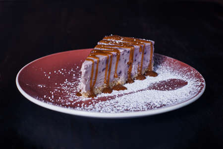 sweet dessert cake on a plate, beautiful serving, dark background.